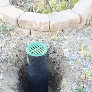 I decided to wrap the perforated drain pipe in landscape fabric to help prevent dirt from filling up the tube.